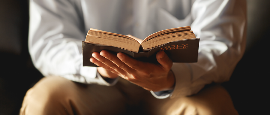 Zoomed in photo of a man holding the Bible open