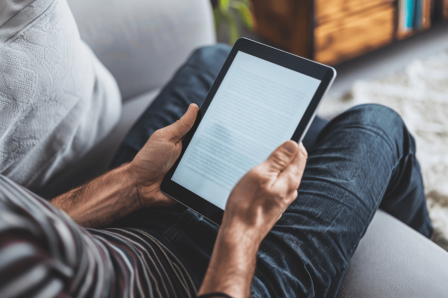 The-Benefits-of-Ebooks-for-Readers-and-Authors Adult man comfortably reading an e-book on a digital tablet