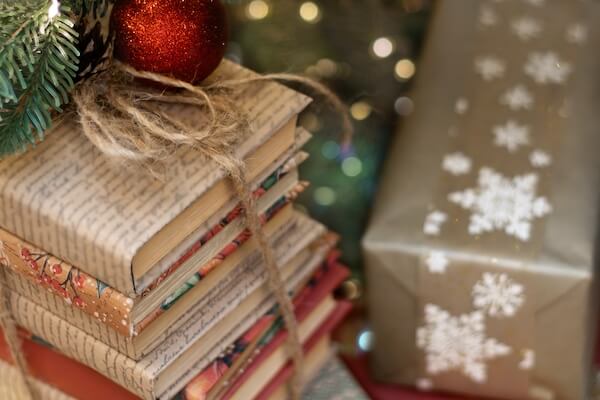 books sitting under a Christmas tree decorated as presents