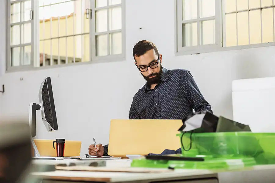 How to Use Your Press Release Kit to Jump-Start Your Book Sales Middle-aged man sitting at a desk preparing a press kit for his upcoming book.