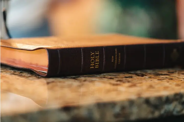 leather bible on a counter with the spine facing the camera and the words Holy Bible written in gold